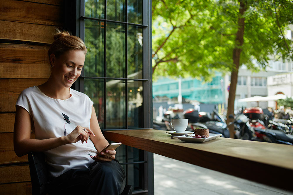 Woman looking at phone at coffee shop