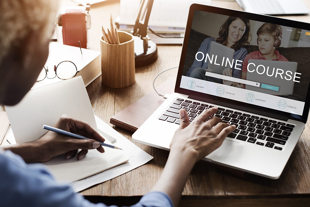 Woman looking at laptop looking at screen that reads "online course"