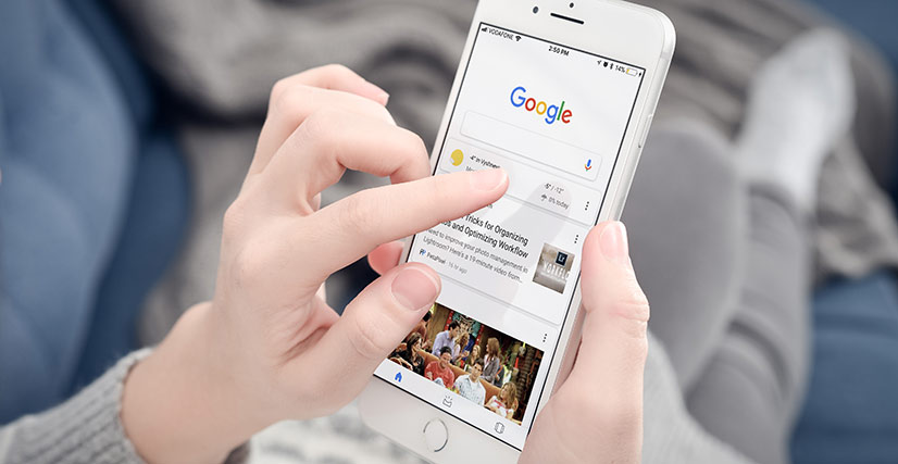 Close up of woman's hand holding smartphone and making a search on Google