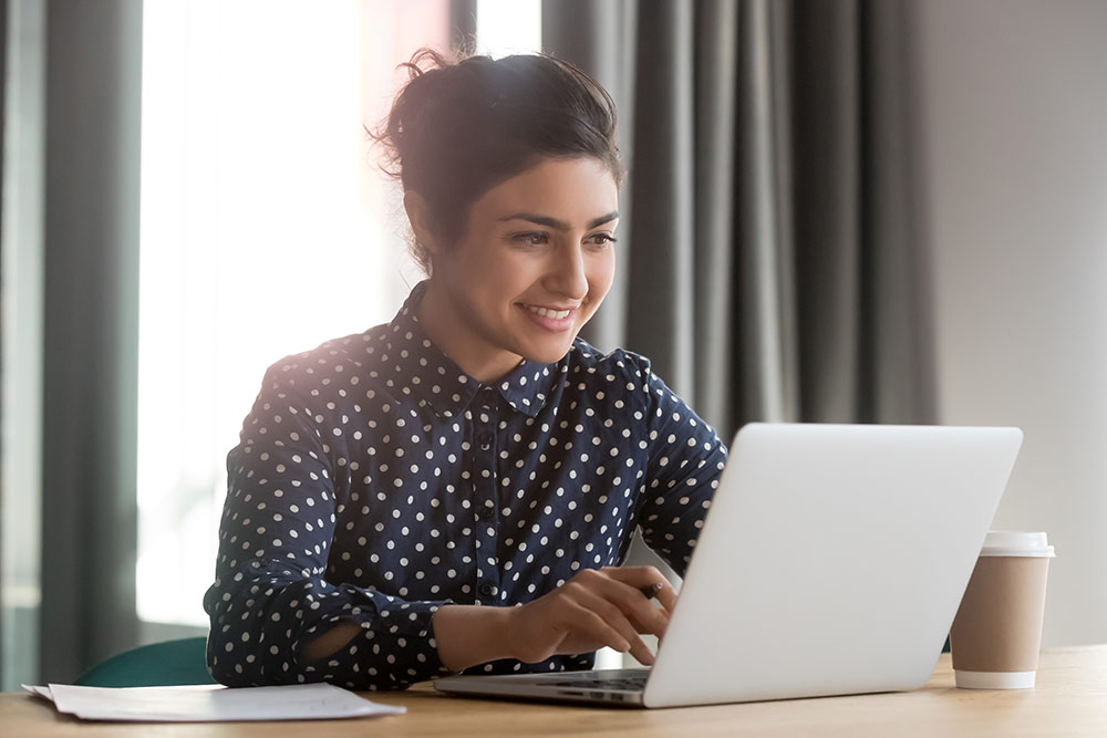 Happy woman smiling while on laptop computer