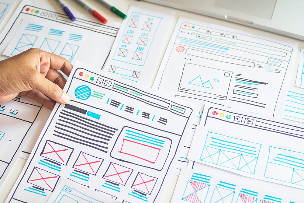 Papers spread out with website design layout sketched on them