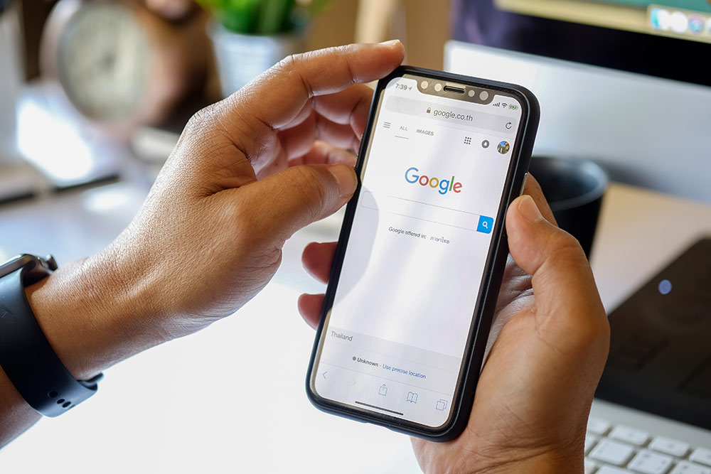 Close up of someone holding phone doing a search on Google