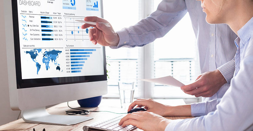 Two people sitting at computer looking at website analytics