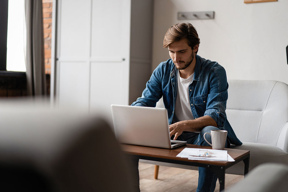 Man sitting on couch on computer