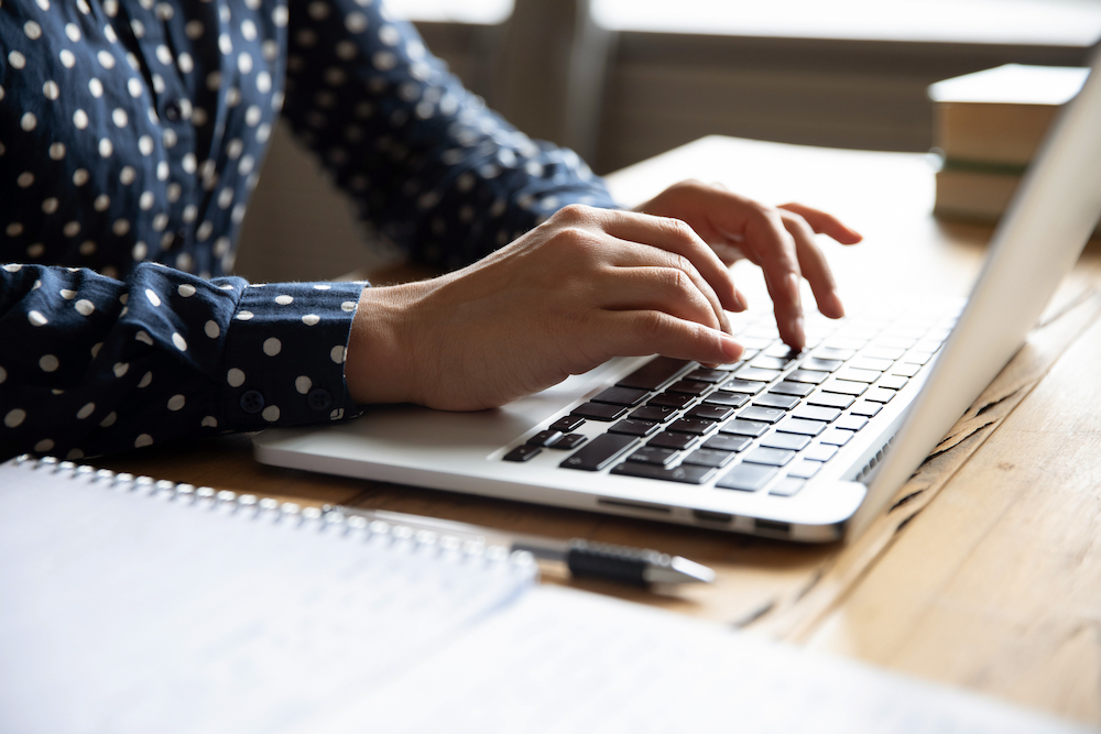 A woman types on her computer